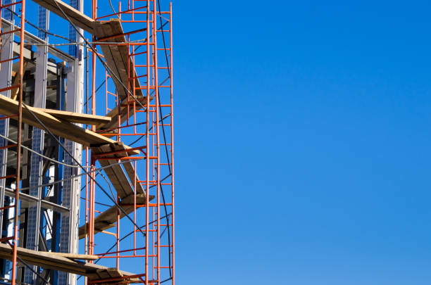 istock scaffolding around the building under construction against a bright blue sky 874804090