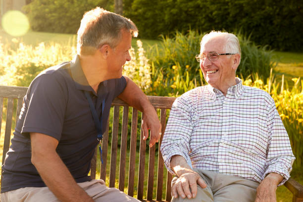 mann besuchen senior männlichen verwandten in einrichtung für betreutes wohnen - senior adult stock-fotos und bilder