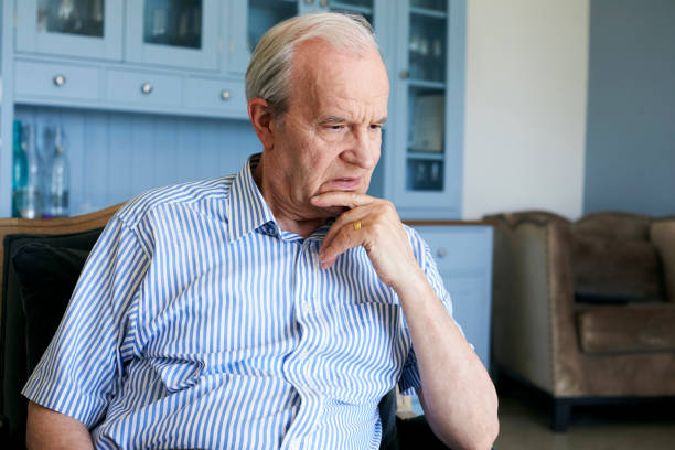 istock Senior Man Sitting In Chair At Home Suffering From Depression 874810696
