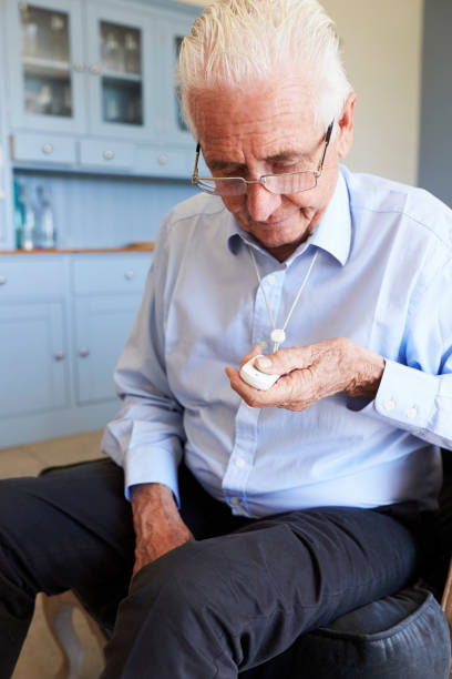 istock Senior Man At Home Using Distress Alarm Call Button 874813770