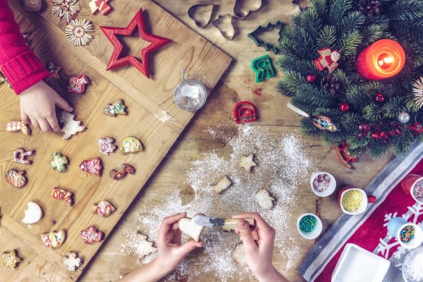 istock siblings decorating christmas cookies together at wooden table 874814540