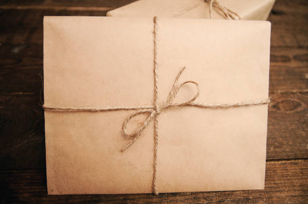 Gift for the holiday with an envelope on a wooden background