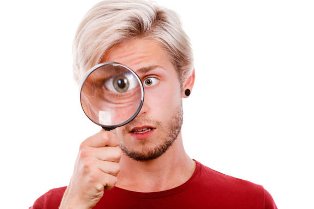 istock man holds on eye magnifying glass looking through loupe 874815292