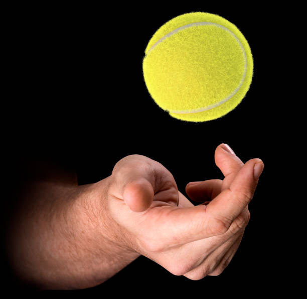 istock Hand Tossing Tennis Ball 874816156