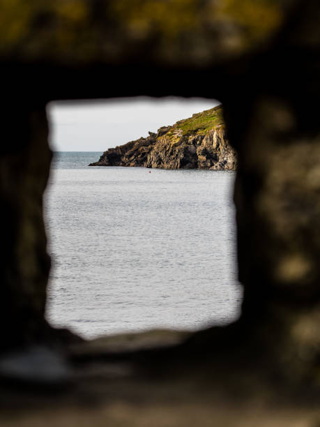 istock Peep hole in bricks looking out to sea 874822982