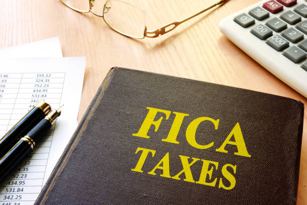 istock FICA Taxes and calculator on a table. 874829160