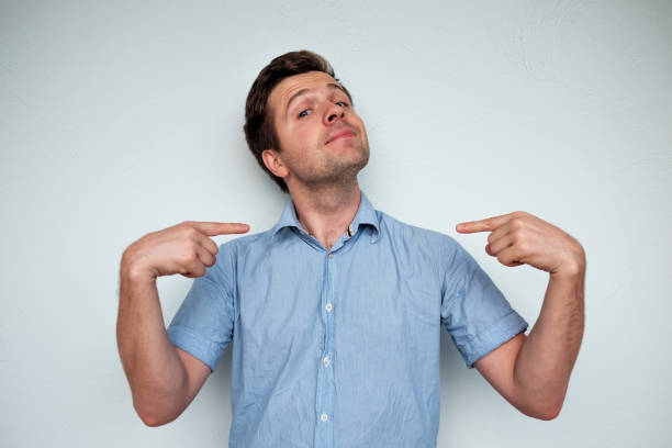 satisfecho de sí mismo y orgulloso hombre joven caucásico espera - smug fotografías e imágenes de stock