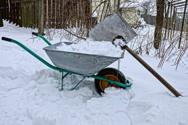 garden equipment with an iron wheelbarrow and a big shovel in the street in the snow
