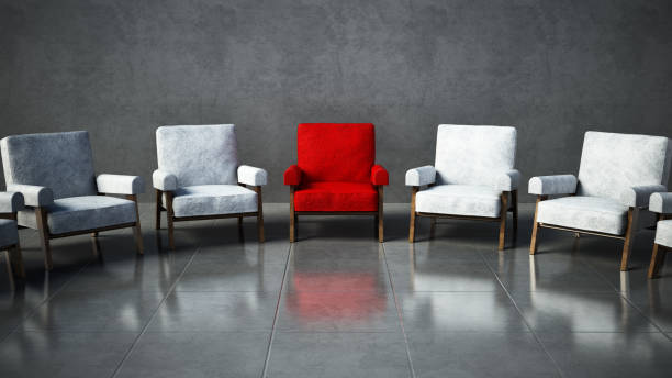 Red chair standing out among white chairs in a room.
