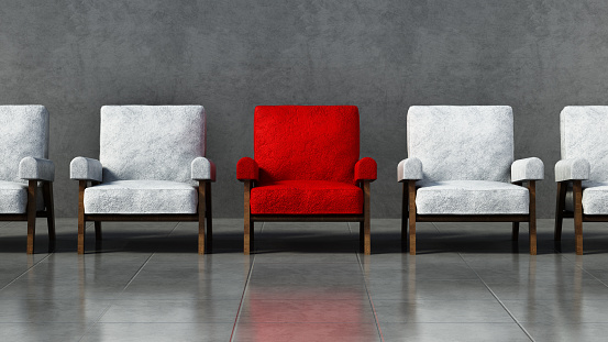 Silla roja destacándose entre sillas blancas en una habitación photo