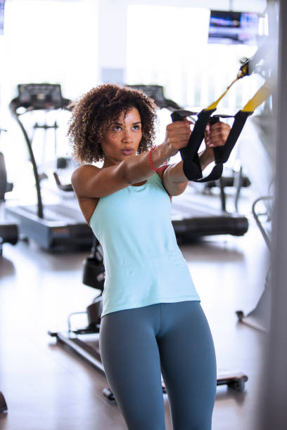 Chest and Arms Workout young woman working out on TRX cables suspension training stock pictures, royalty-free photos & images