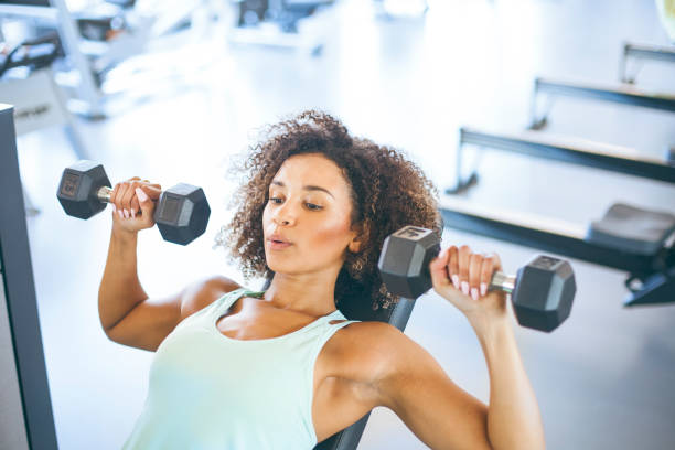 junge frau weighraining im gym - oberkörperaufnahme stock-fotos und bilder