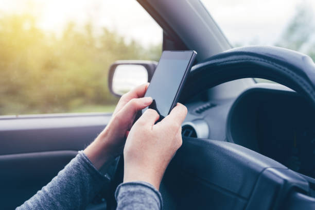 istock Woman simultaneously driving car and typing text message 874837116