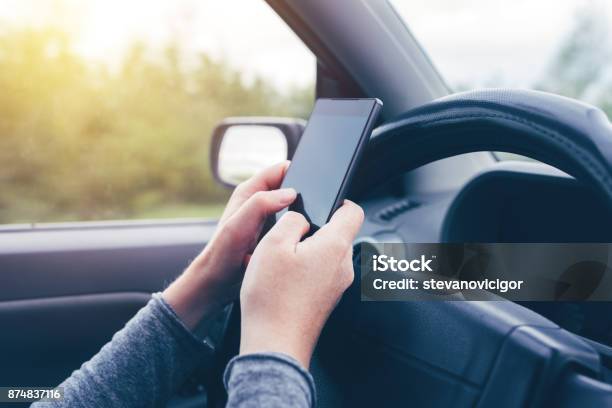 Woman Simultaneously Driving Car And Typing Text Message Stock Photo - Download Image Now