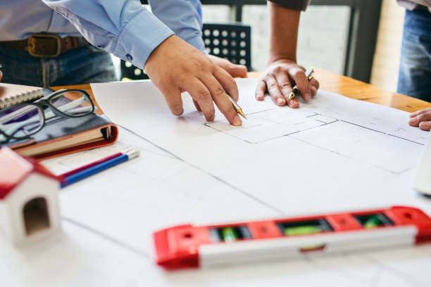 istock Architecture engineering teamwork meeting at workplace to plan drawing a new blueprint busy working hard for apartment building small business of their customer service. 874841410