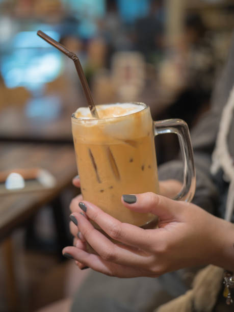 Woman hand holding iced coffee in the coffee shop stock photo