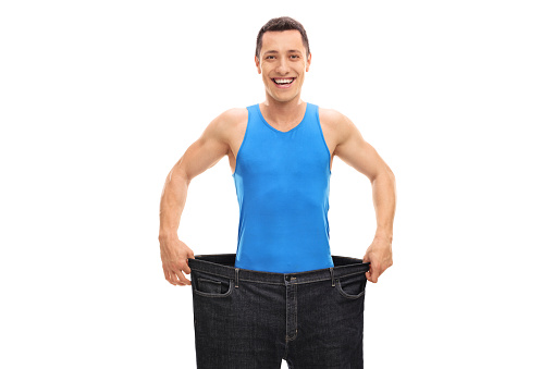 Happy guy in a pair of oversized jeans isolated on white background