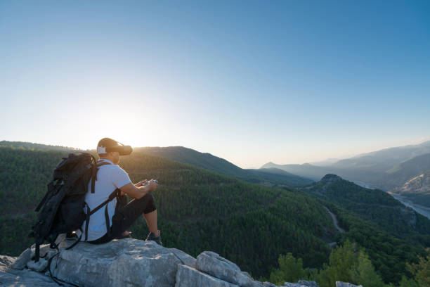istock Hiker Drone pilot using fpv goggles to fly  in the mountain 874851852
