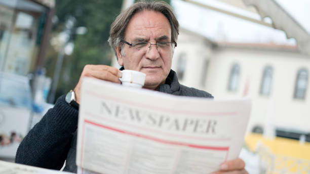 istock Senior man reading newspaper in outdoors 874855320