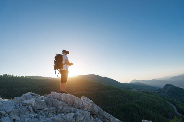 istock Hiker Drone pilot using fpv goggles to fly  in the mountain 874855896
