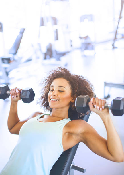 istock Young Woman Weightraining at the Gym 874859890