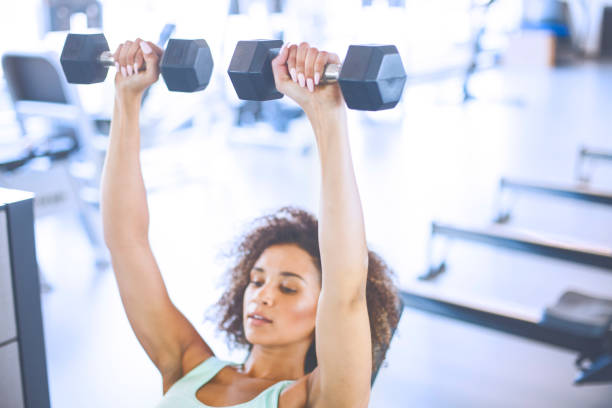 istock Young Woman Weightraining at the Gym 874859894