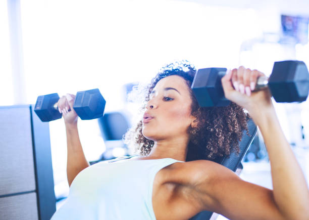 istock Young Woman Weightraining at the Gym 874859904