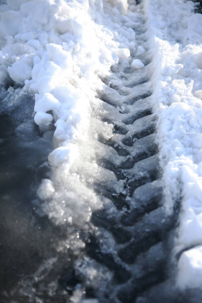 istock Snow traces of car tires 874860268