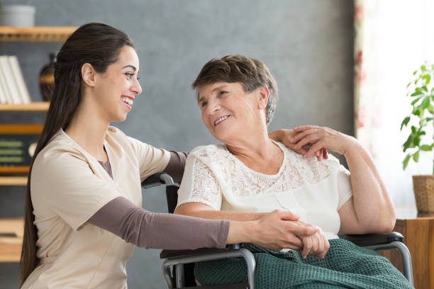 istock Friendly caregiver woman hugging senior 874861820