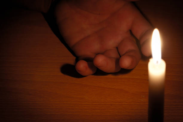 istock dead hand and the light from the candles 874863224