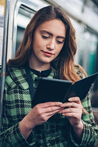 istock Girl reading from a digital tablet in the subway train 874863548