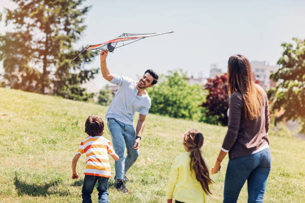 istock Family with two children releasing a kite 874863580