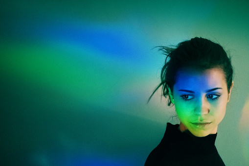 Young girl with rainbow reflections on her face.