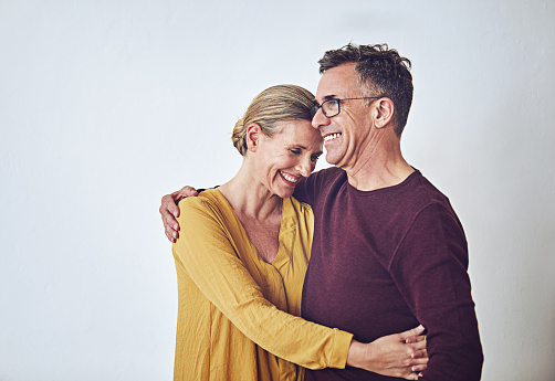 Studio shot of an affectionate mature couple posing against a grey background