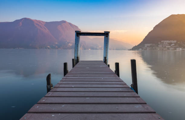 Sunset at Lake Lugano, Switzerland with wooden jetty as the foreground stock photo