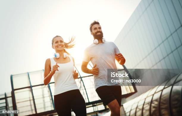 Young Fitness Couple Running In Urban Area Stock Photo - Download Image Now - Running, Couple - Relationship, Jogging