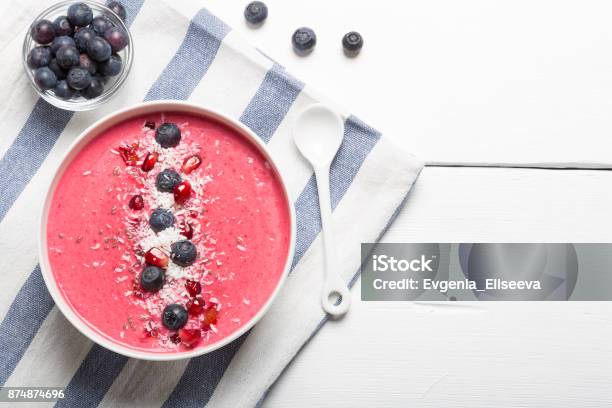 Strawberry And Beetroot Smoothie Bowls Topped With Blueberries Pomegranate Seeds And Shredded Coconut On A White And Blue Striped Clothe Top View Copy Space Stock Photo - Download Image Now