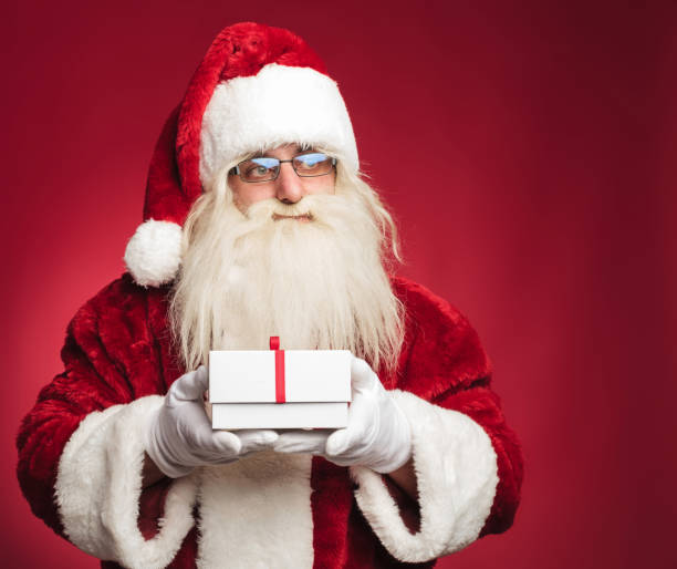 istock side view of santa claus holding a present box 874875982