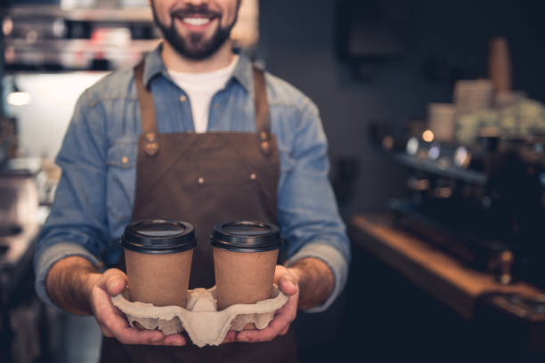 Happy worker holding cups of beverage