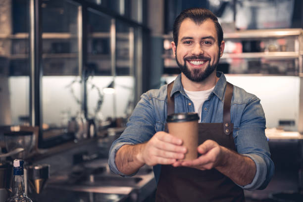 istock Smiling worker holding cup of beverage 874876210
