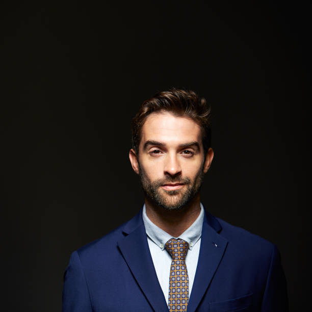 Studio portrait of a handsome young businessman posing against a dark background