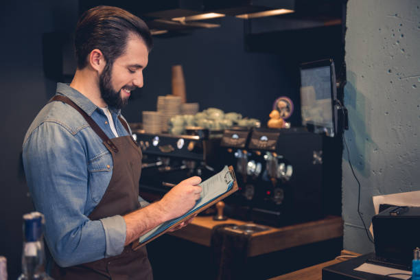 istock Happy worker writing information in confectionary shop 874878710
