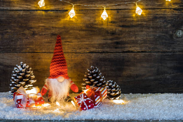 istock Little Christmas dwarf with presents and wooden background 874880072