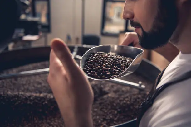 Photo of Serious male smelling coffee grains