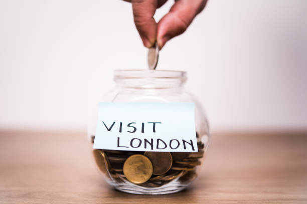 istock Hand dropping a coin in a jar that has 