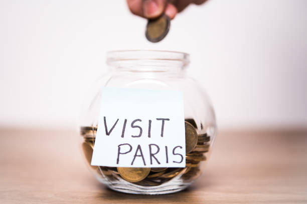 istock Hand dropping a coin in a jar that has 