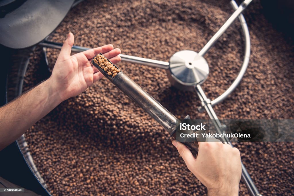 Man arms controlling frying beans Top view close up male hand keeping special scapula stick with burnt seeds. Check concept Customer Service Representative Stock Photo