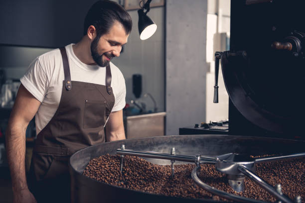 istock Happy unshaven worker looking at coffee beans 874884934