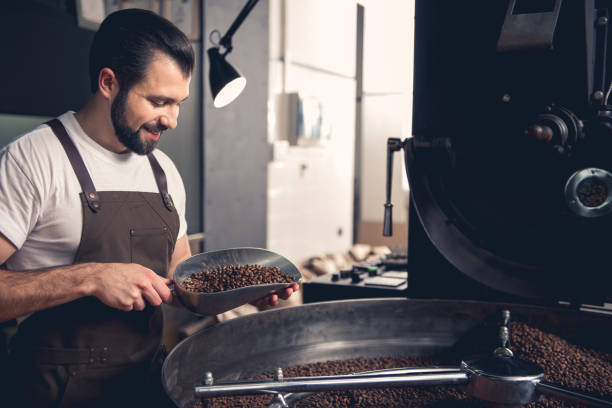 istock Happy man keeping spatula with coffee beans 874887080