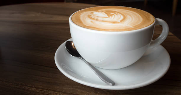 istock hot coffee in white cup on wood desk 874887668